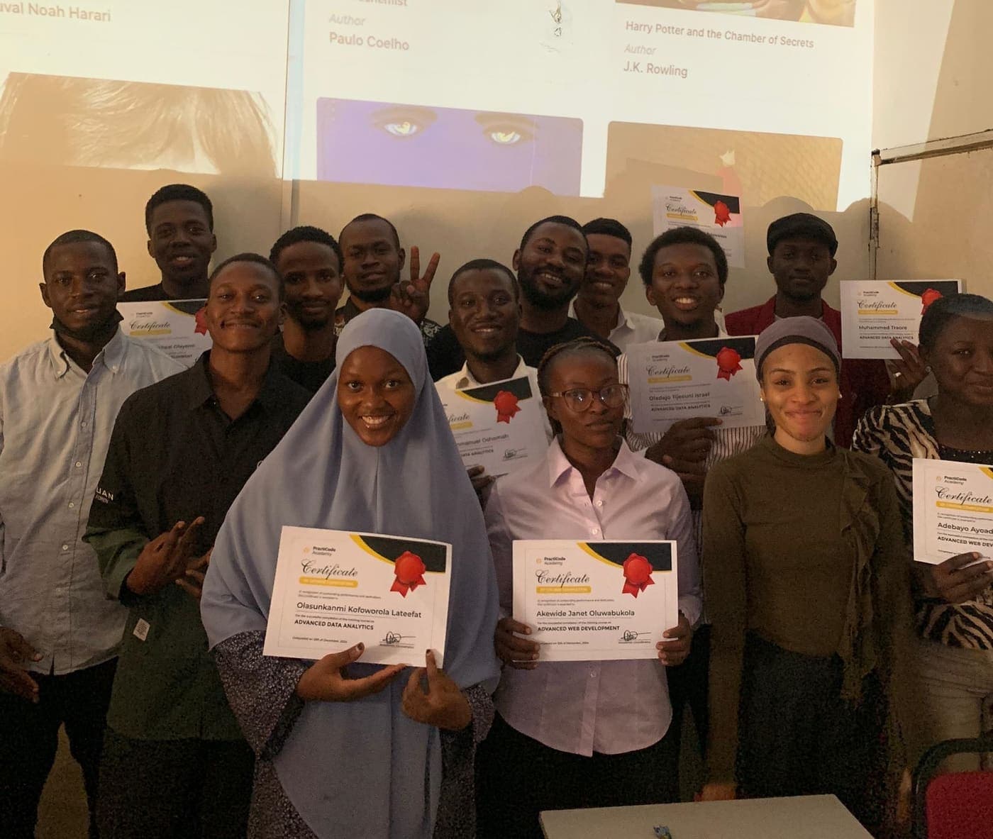 Graduates holding PractiCode Academy certificates